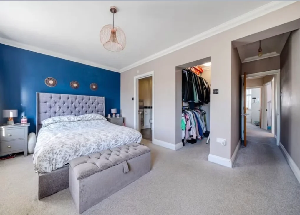 Bedroom interior painting with blue feature wall and neutral tones in a Bromley home